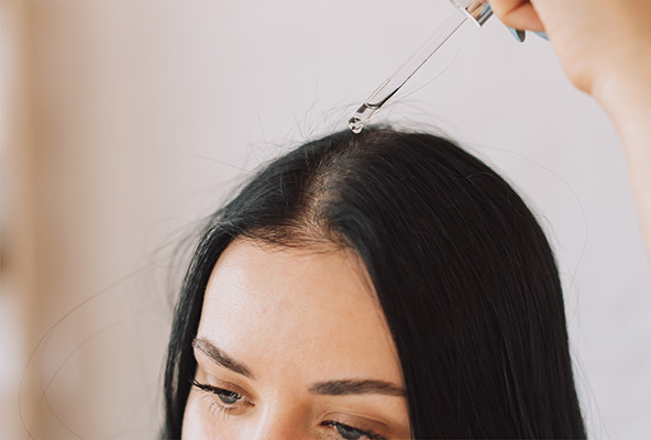 woman applying scalp drops woman applying scalp drops